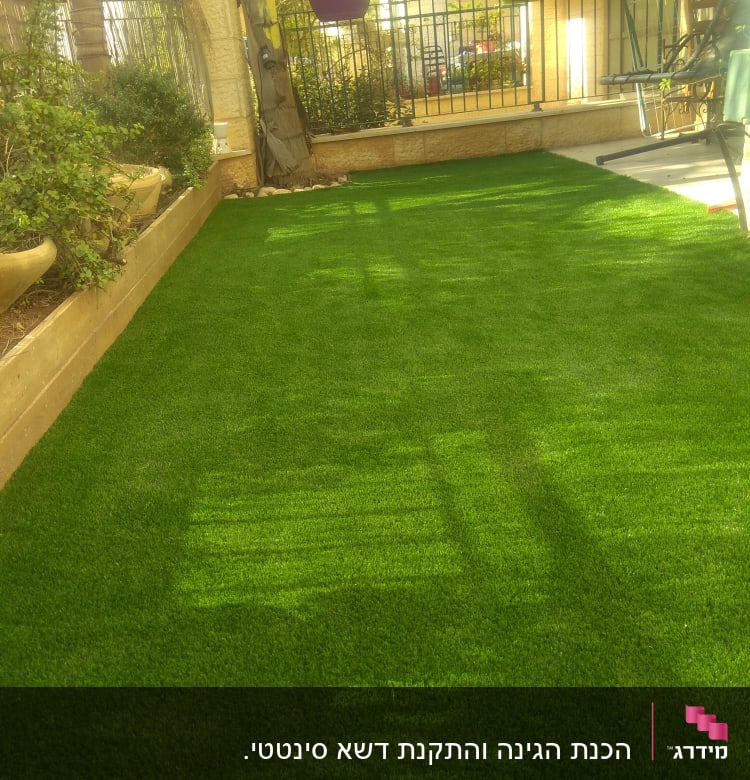 דשא סינתטי עם עציצים תלויים בגינה